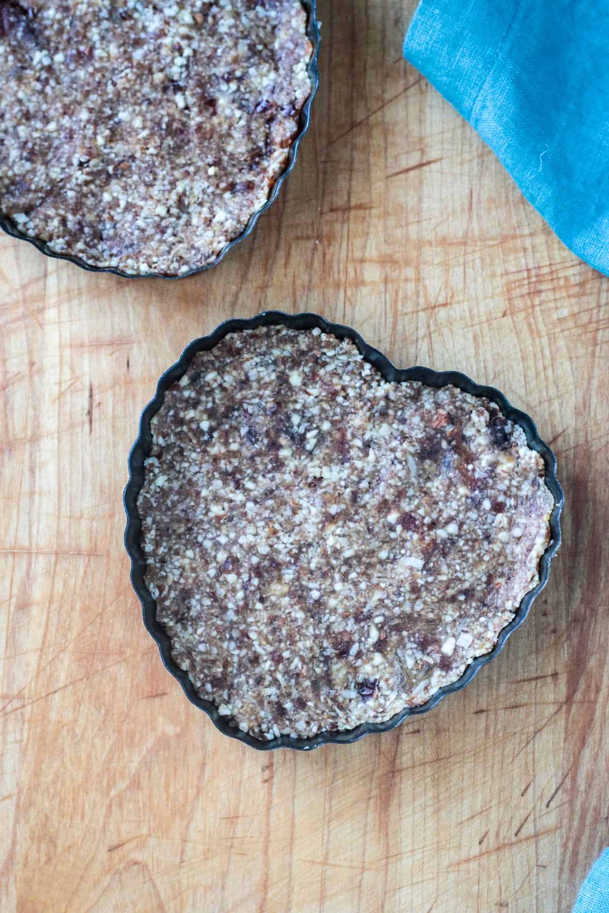 Crust pressed into heart shaped tart pans.