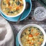 Two bowls of soup next to a glass of water.