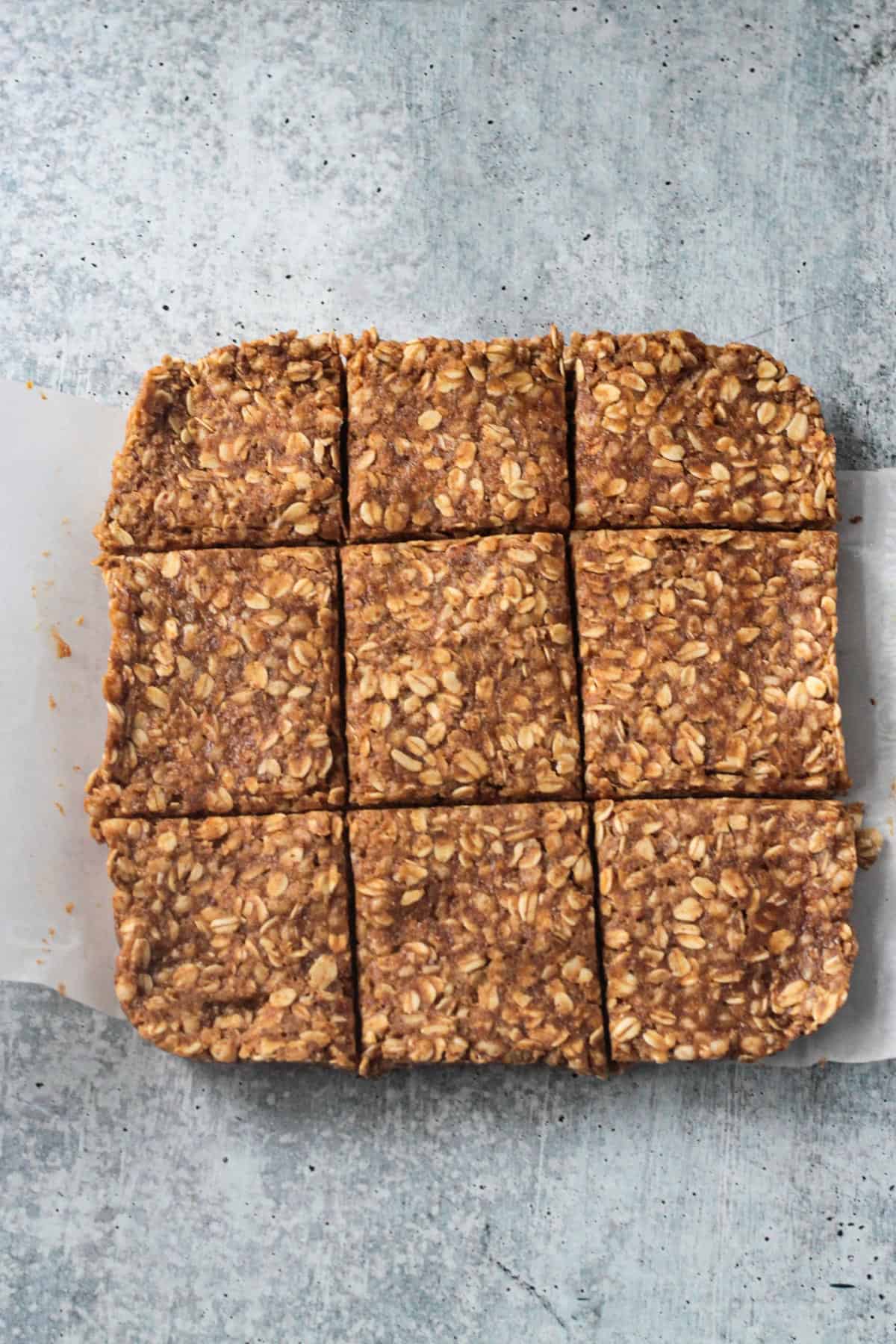 Square of oatmeal bars cut into 9 slices.
