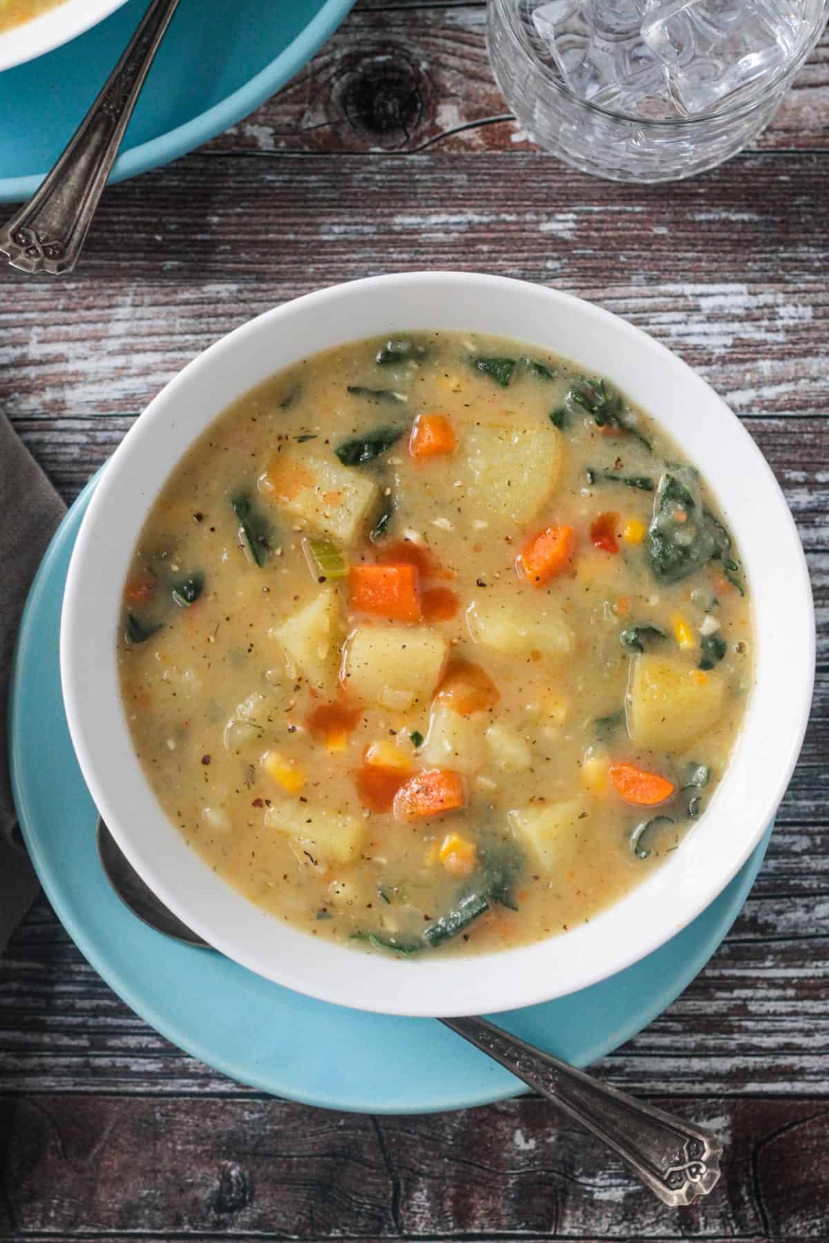 Vegan potato soup in a white bowl on a blue plate.