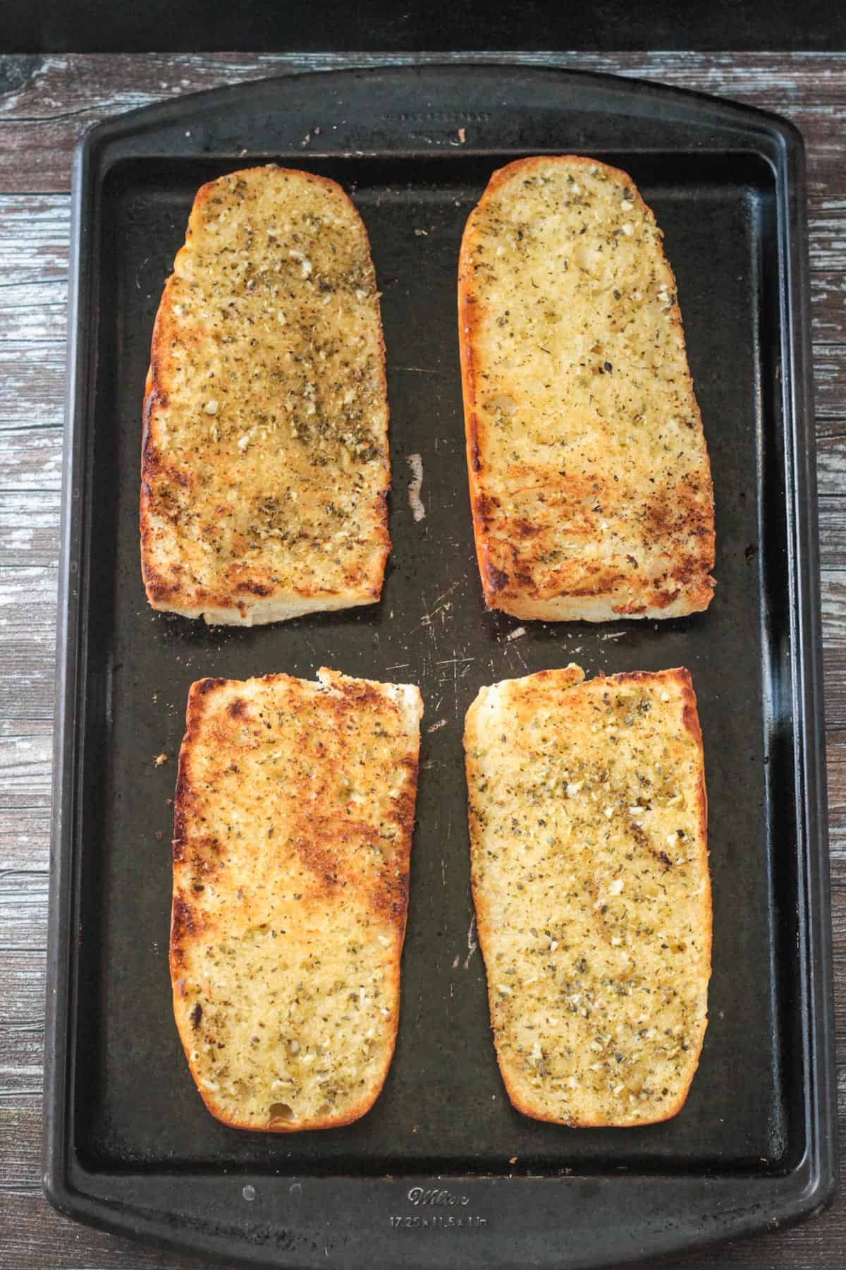 Finished vegan garlic bread on a baking sheet.