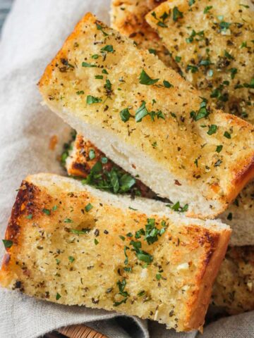 Slices of fresh baked vegan garlic bread in a basket.