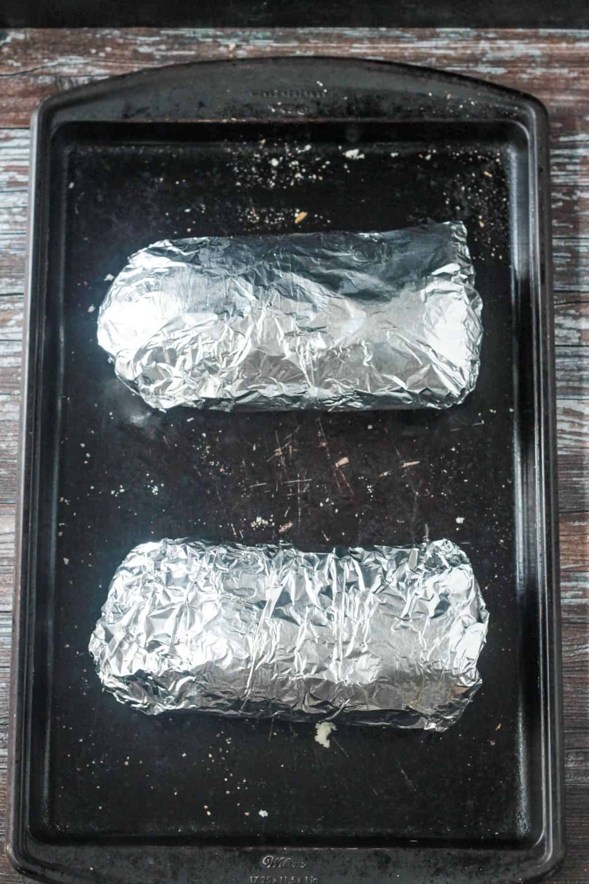 2 halves of a pre-baked garlic bread loaf wrapped in foil.