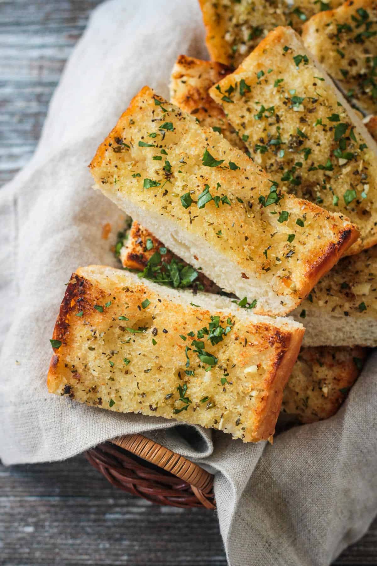 Slices of fresh baked vegan garlic bread in a basket.
