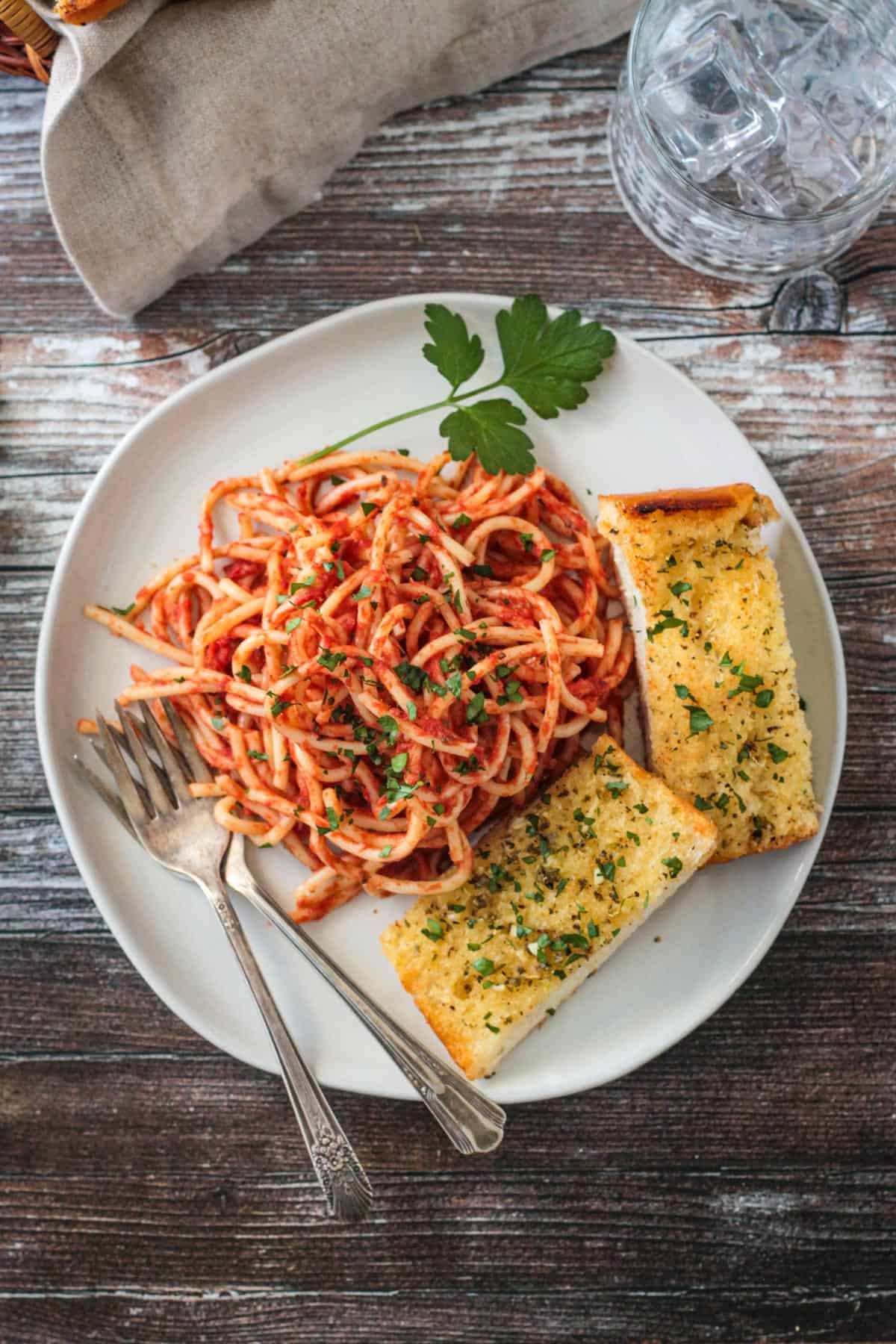 Plate of spaghetti with two slices of garlic bread.
