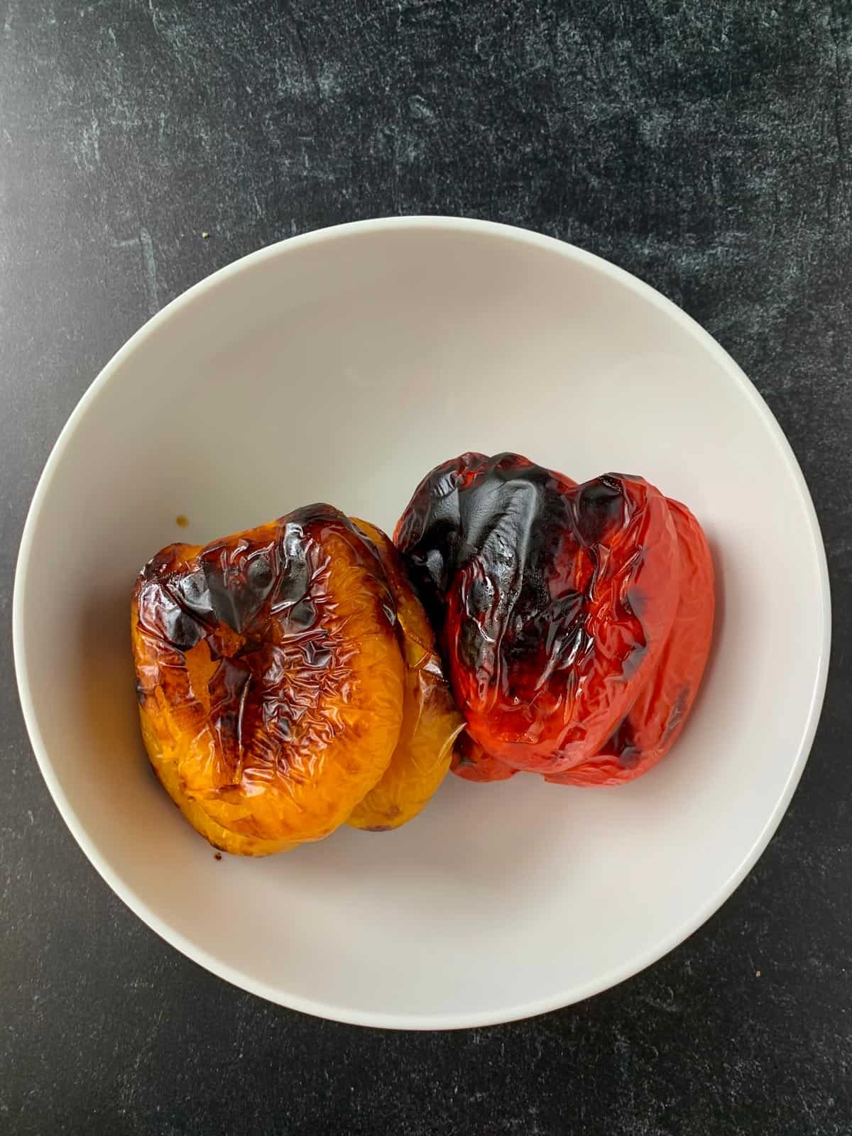 One  red and one yellow bell pepper roasted until blackened.