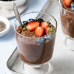 Metal spoon in pudding in a glass parfait bowl