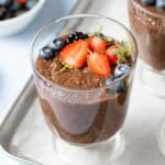 Fresh strawberries and blueberries on top of a bowl of chocolate chia pudding.