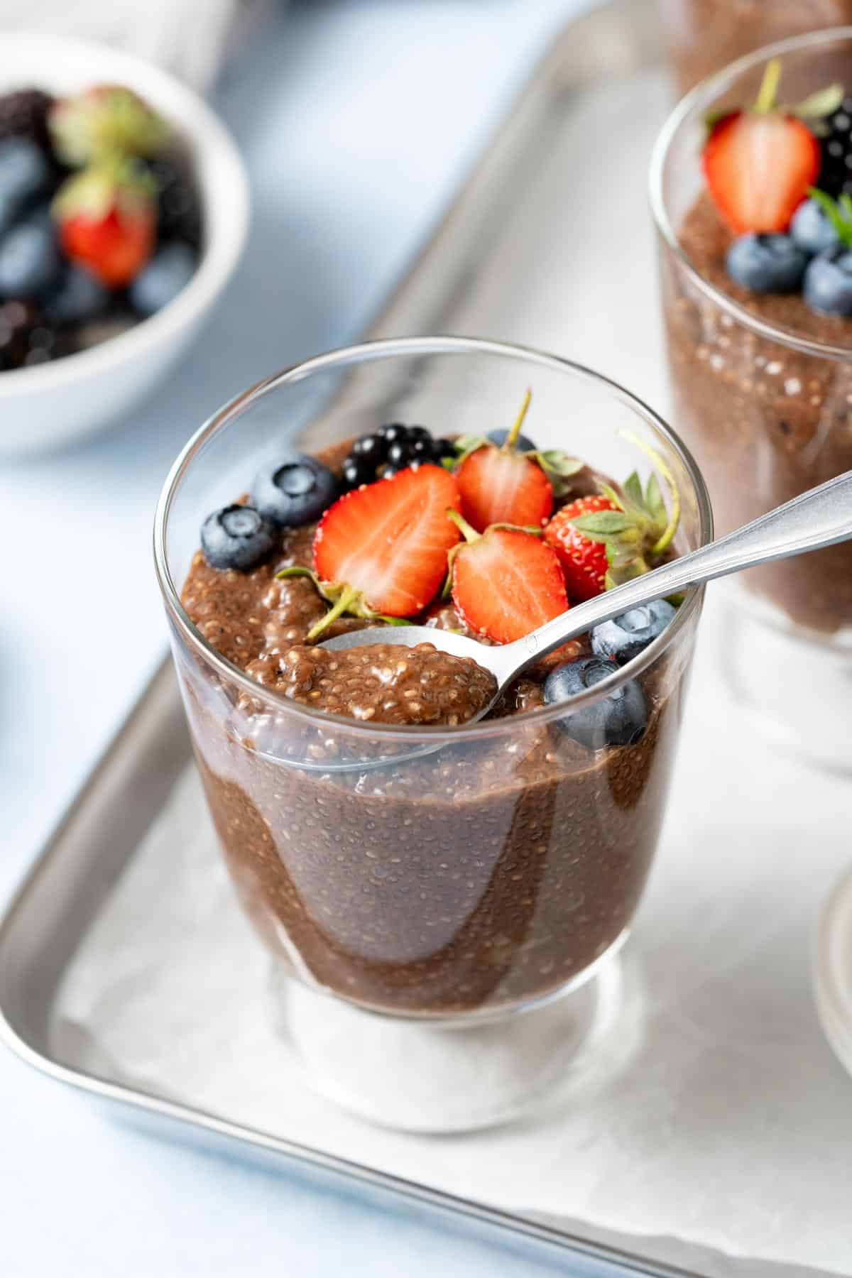 Spoonful of chocolate chia pudding being lifted from a glass.