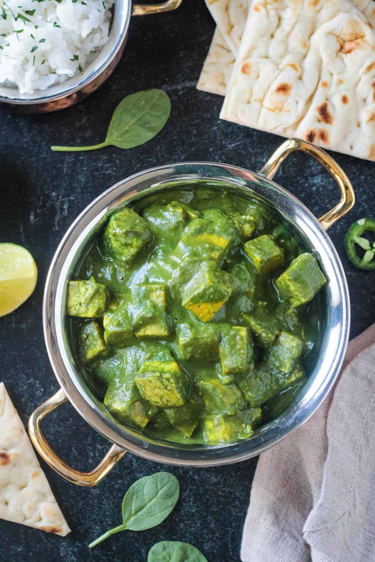 Overhead view of a serving pot of vegan palak paneer.