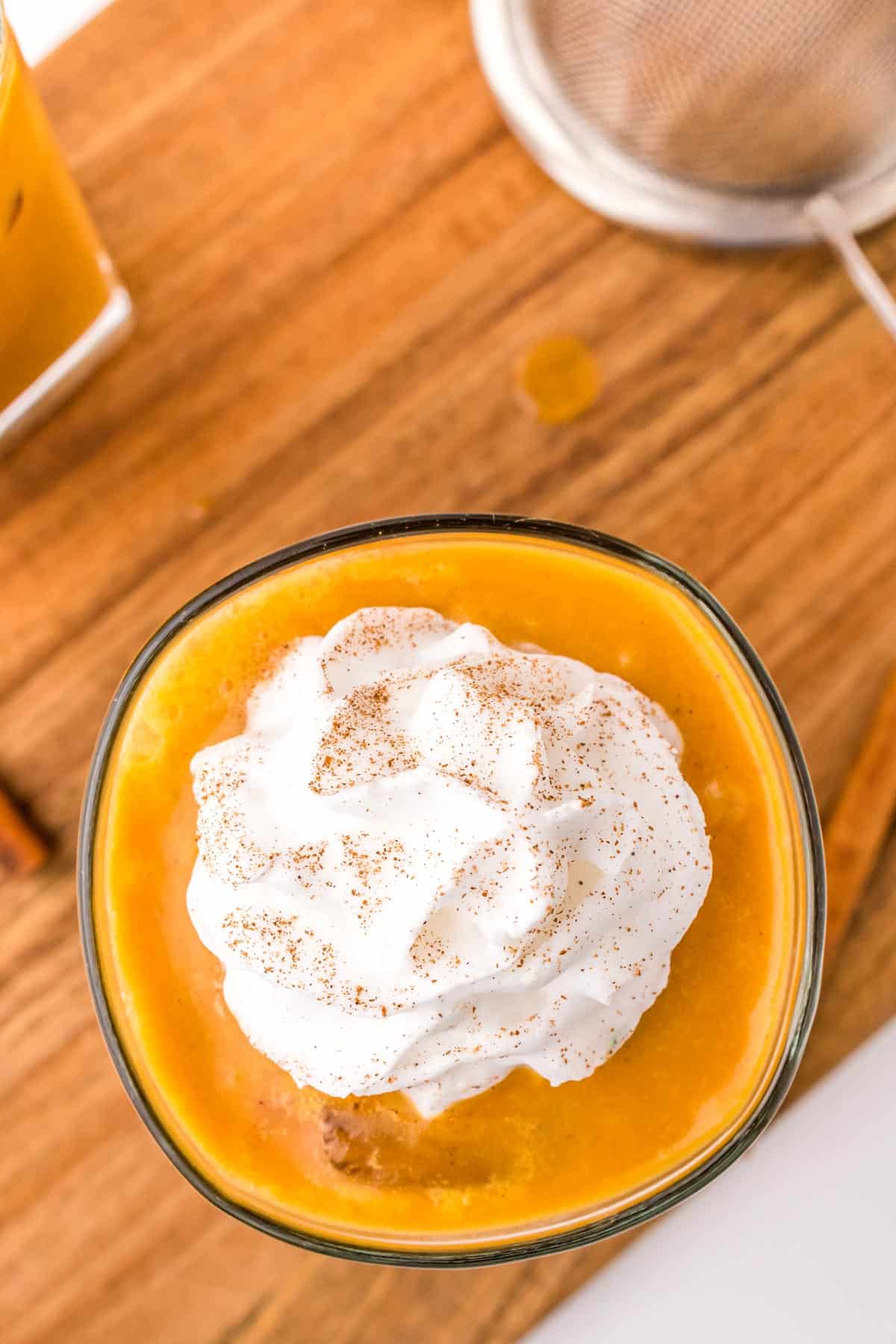Overhead view of a pumpkin spice coffee topped with a dollop of whipped cream.