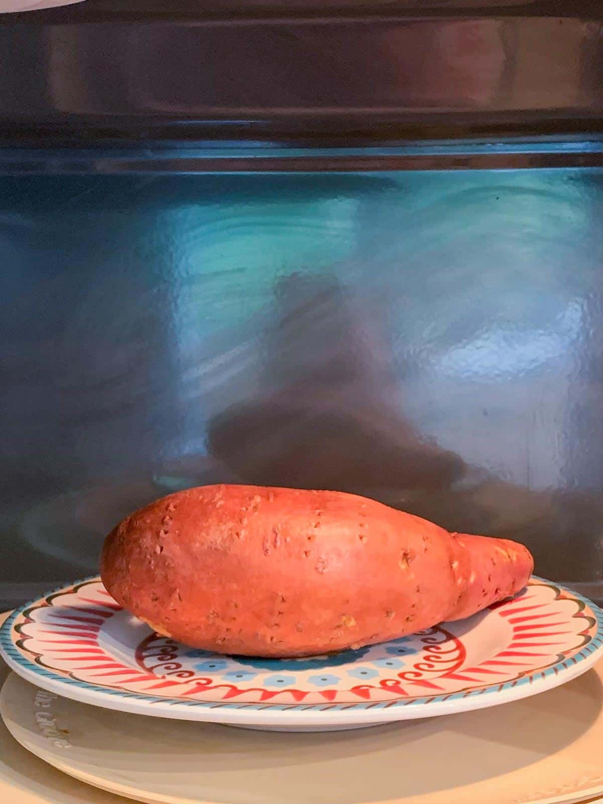 Sweet potato on a plate in a microwave.