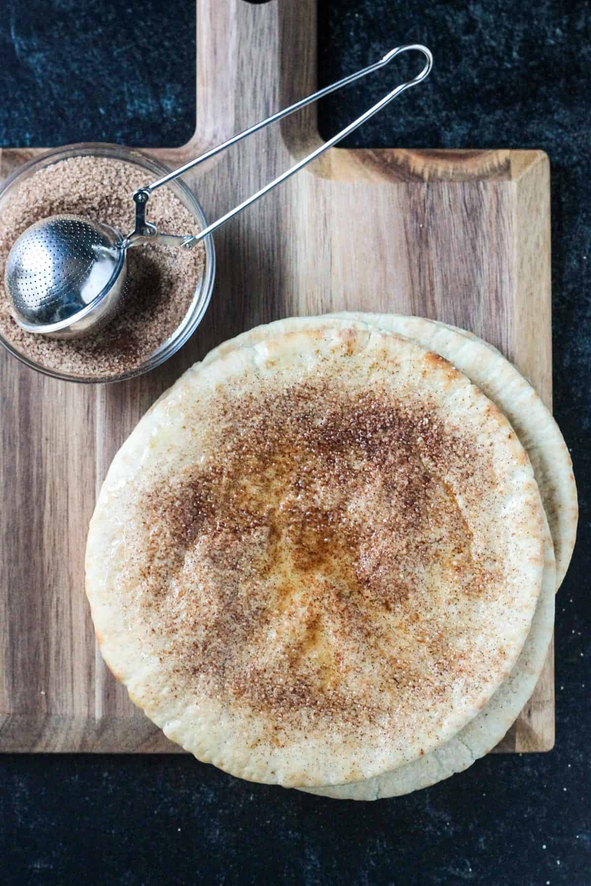 Cinnamon sugar mixture sprinkled on a pita bread circle.