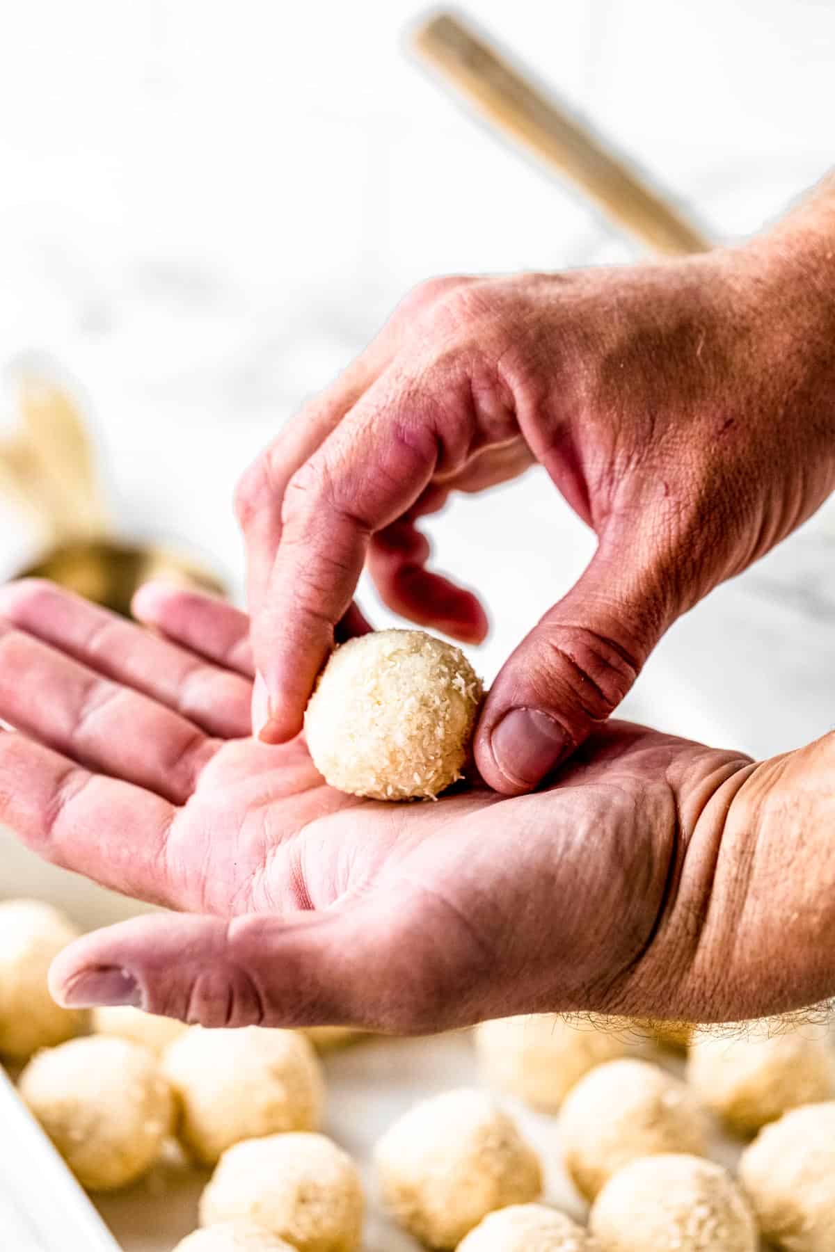 Hand forming a ball with the dough.