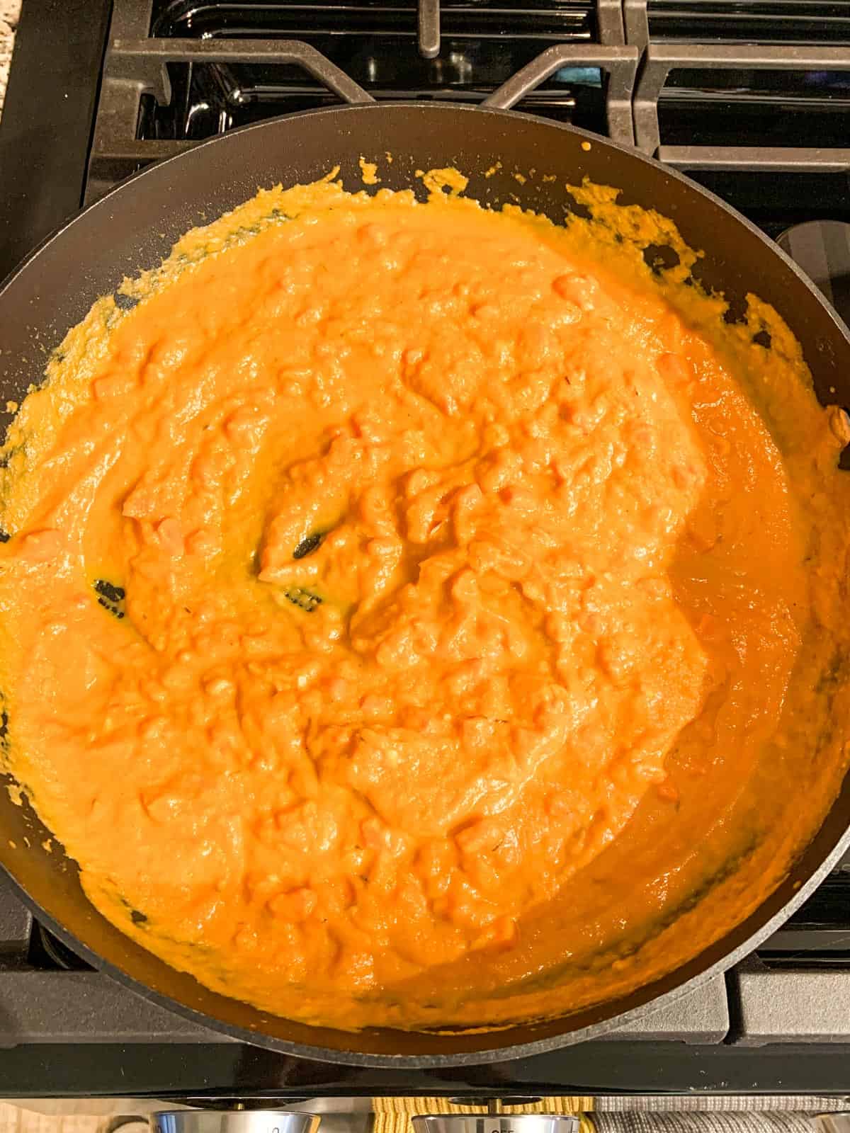 Pumpkin pasta sauce simmering in a skillet.
