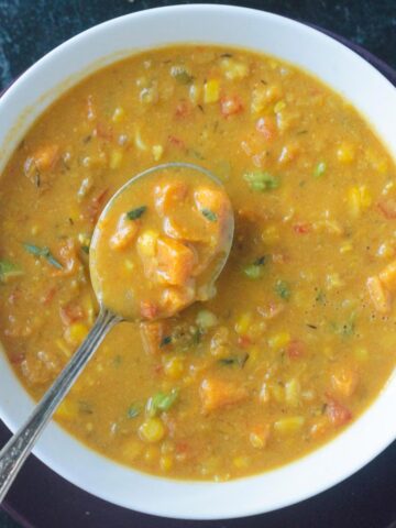 Spoonful of soup being lifted from a bowl.