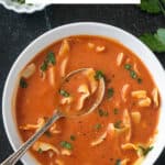 Polish tomato soup garnished with fresh cracked black pepper and chopped parsley.