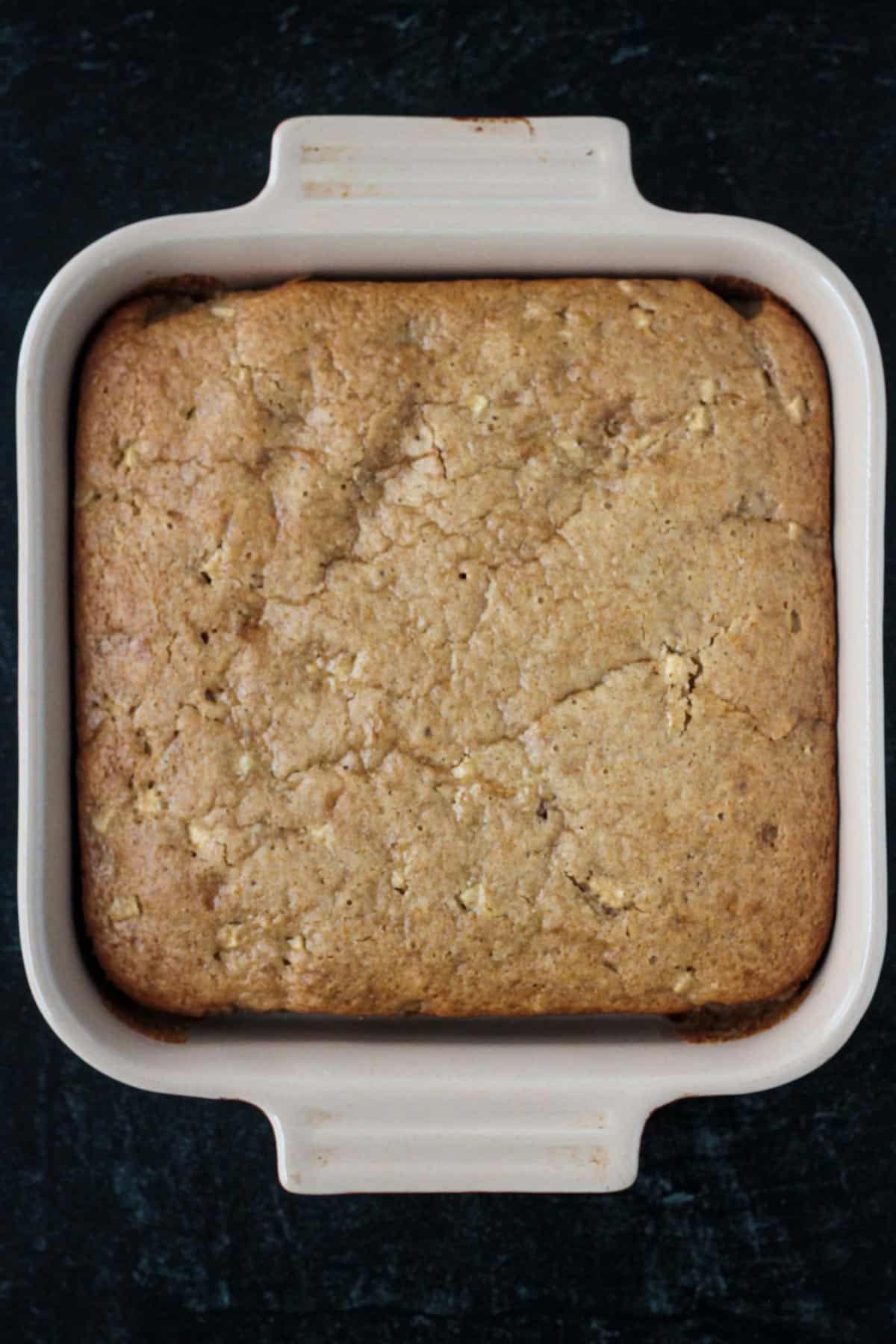 Baked vegan apple cake in a square baking dish.
