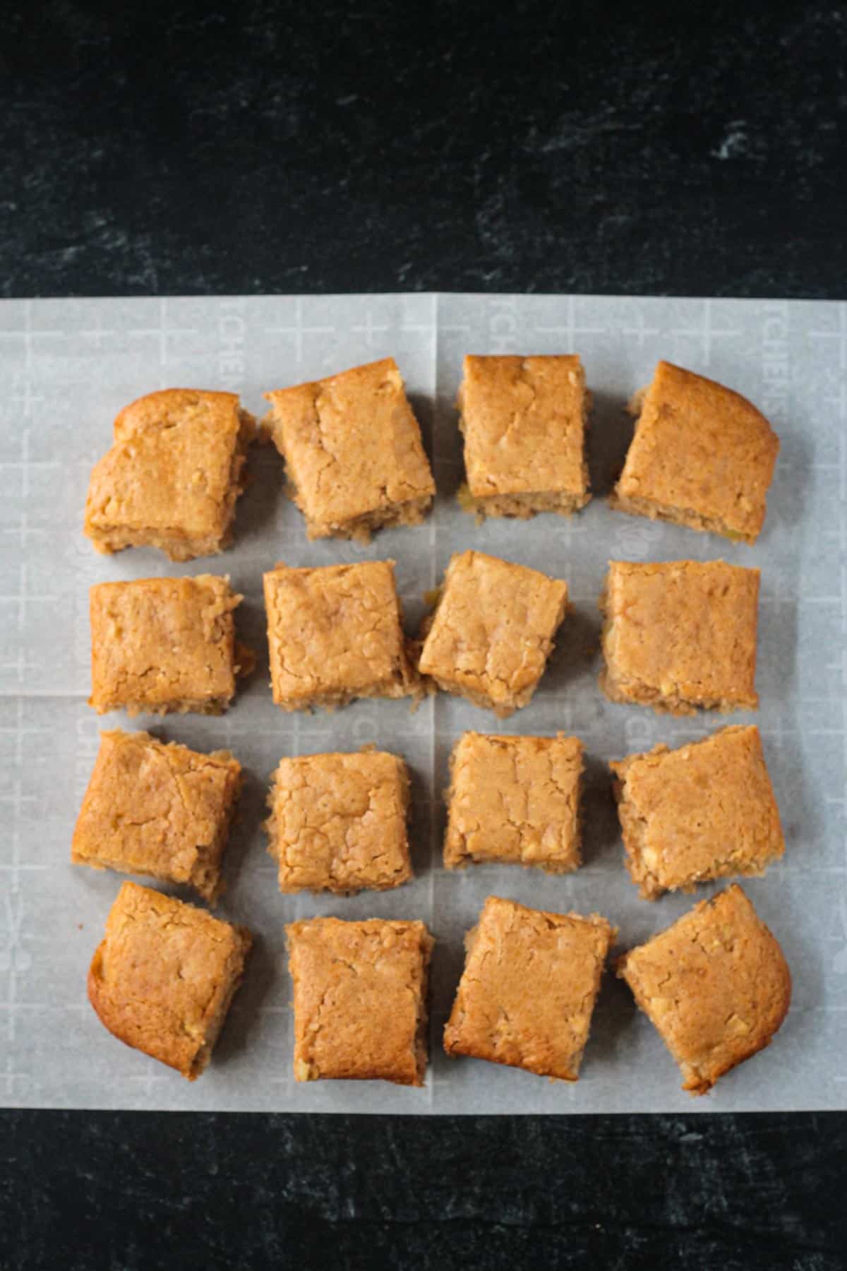 Baked cake cut into 16 equal sized squares.