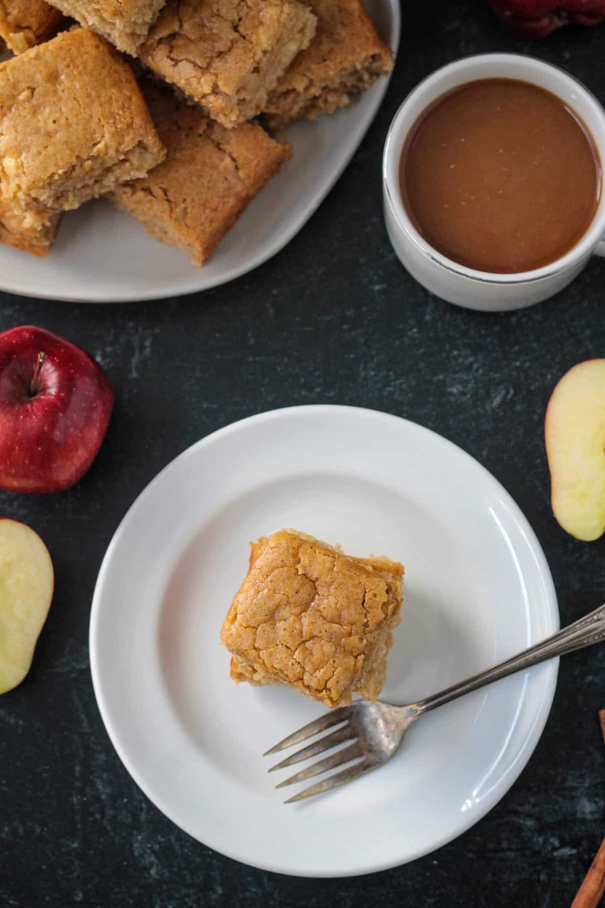 Slice of vegan apple cake on a plate with a fork.