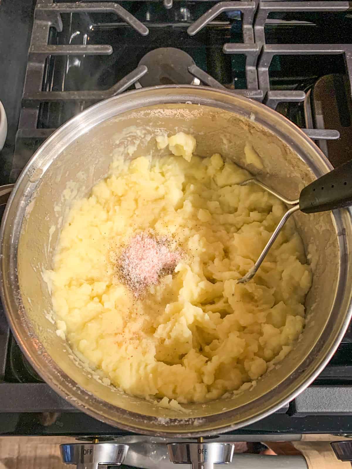 Mashing the yukon golds with a potato masher.