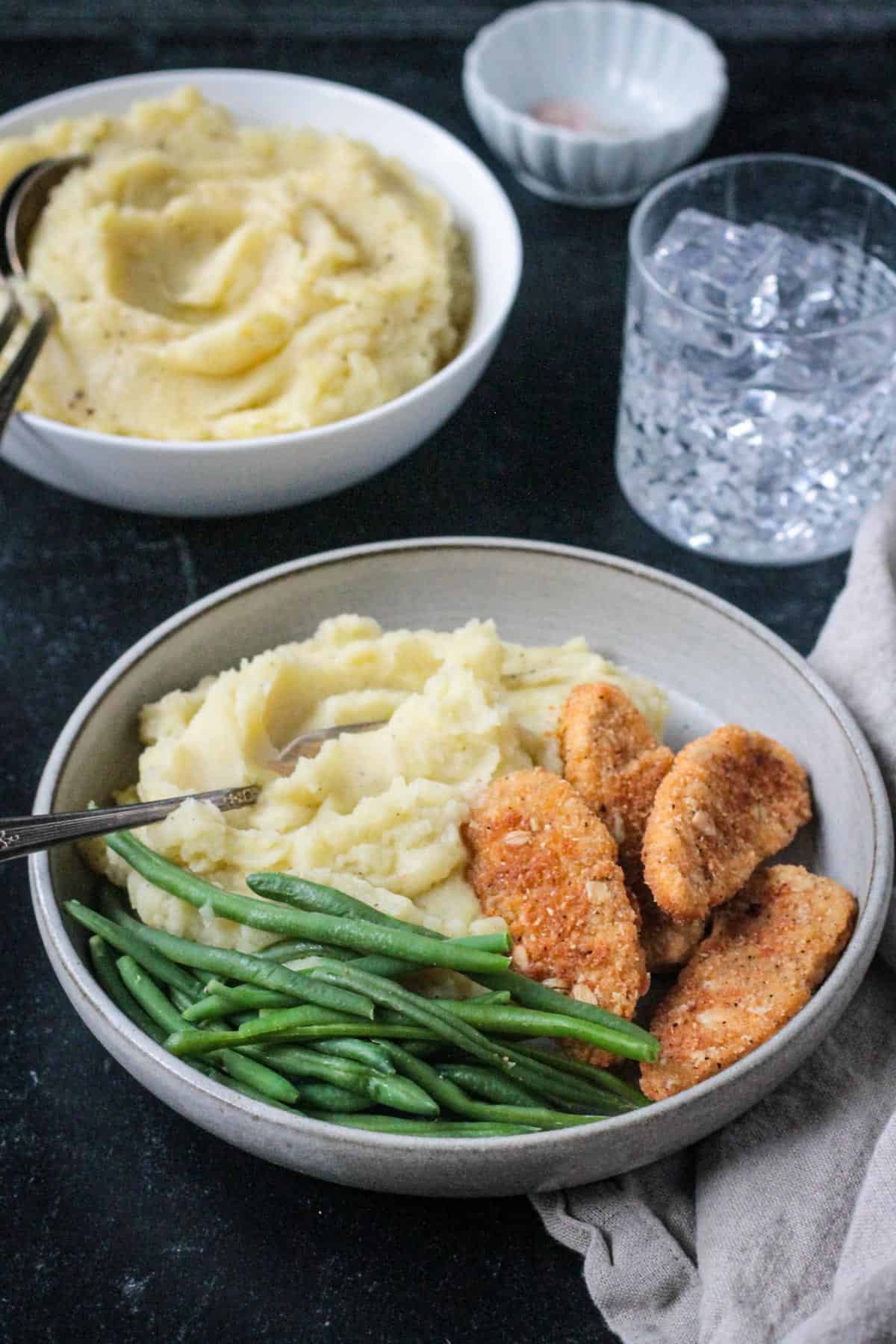 Plate of chicken tenders, green beans, and mashed potatoes.