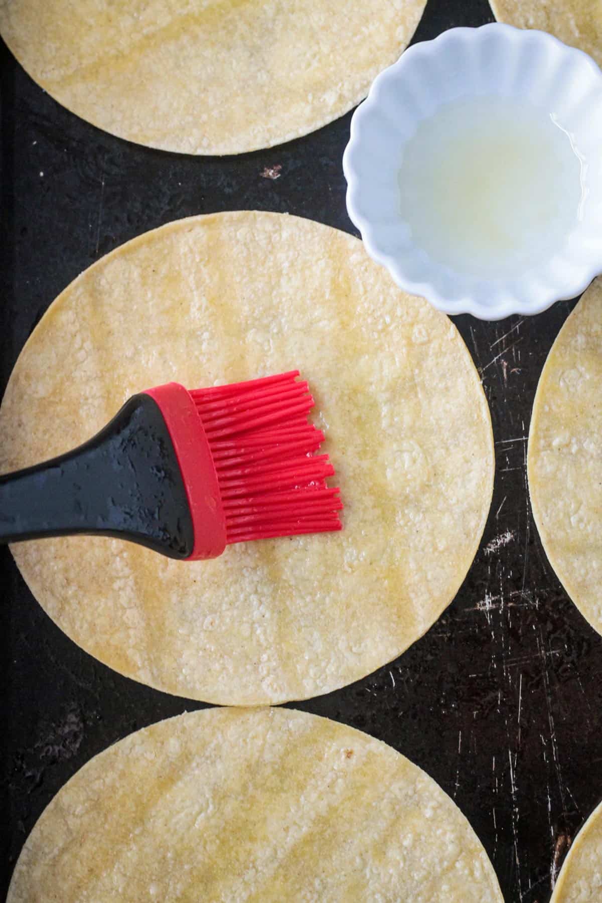 Silicone pastry brush brushing oil onto a tortilla.