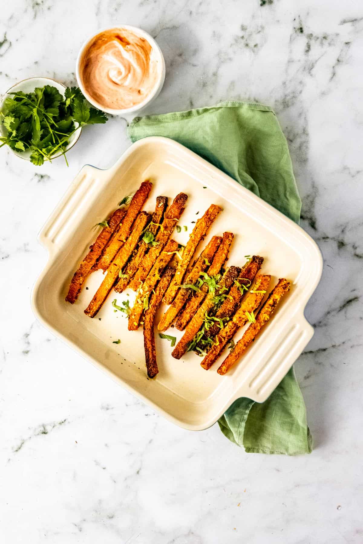 Oven baked butternut squash fries in a baking dish.