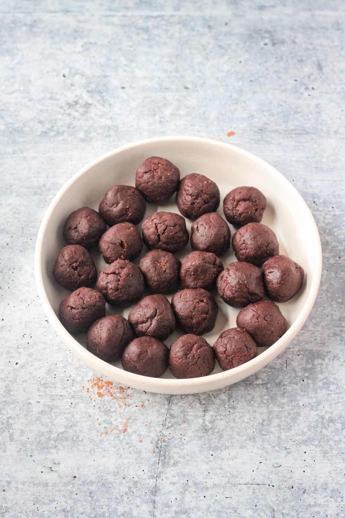 A plate full of chocolate dough balls.