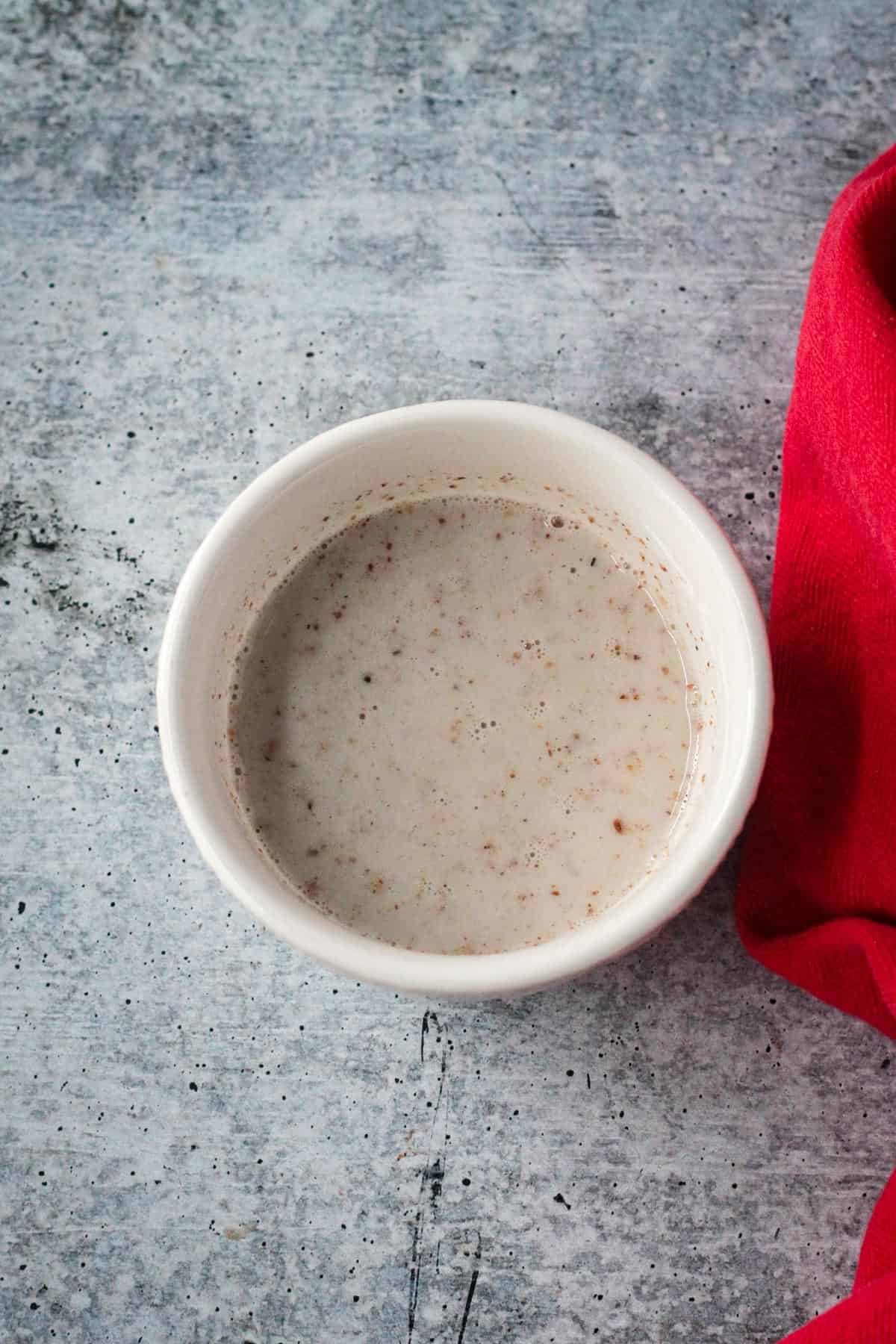 Flax seed meal and milk whisked together in a small bowl.