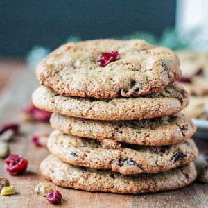 Stack of 5 vegan cranberry cookies on a wooden board.