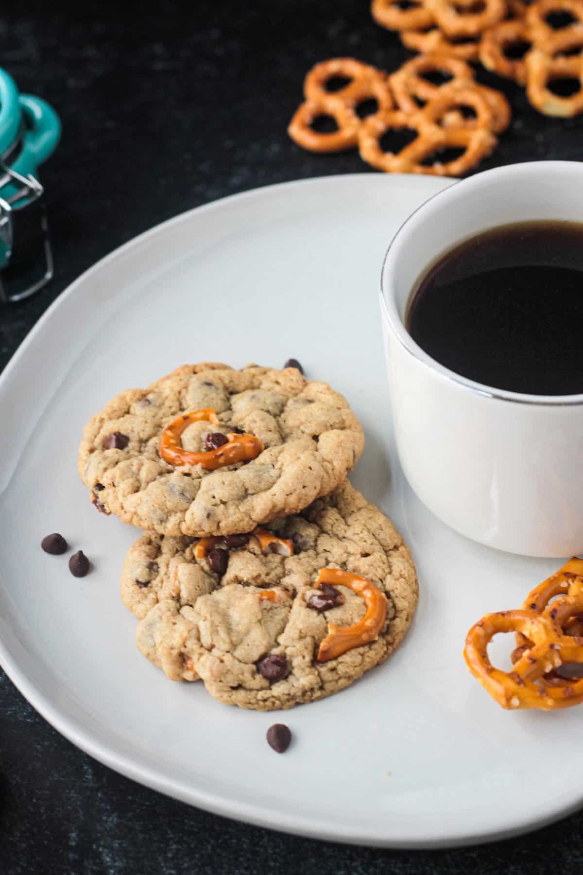 Two chocolate chip pretzel cookies on a plate.