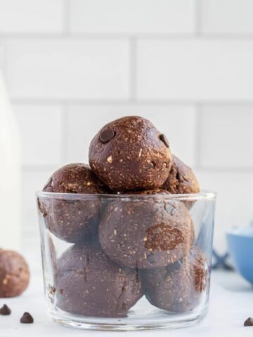 Edible brownie batter balls piled up in a small parfait glass.
