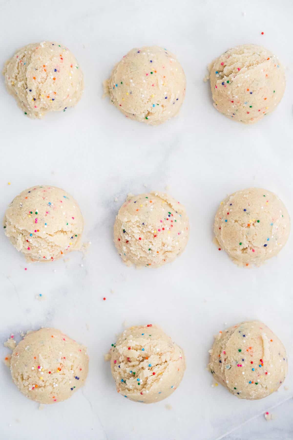 Nine scoops evenly spaced in a three by three grid on a baking sheet.