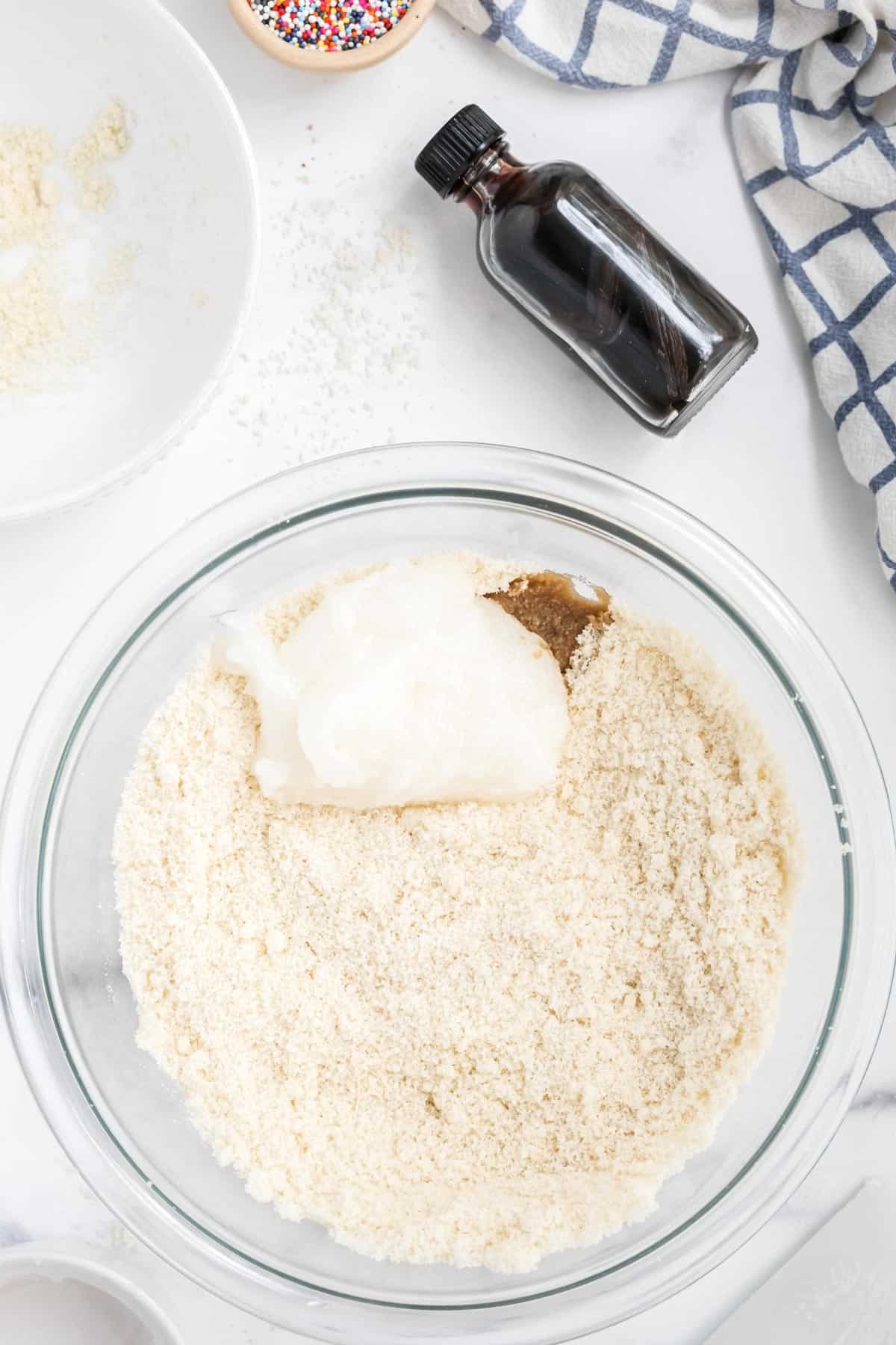 Adding coconut oil and vanilla to the dry ingredients.