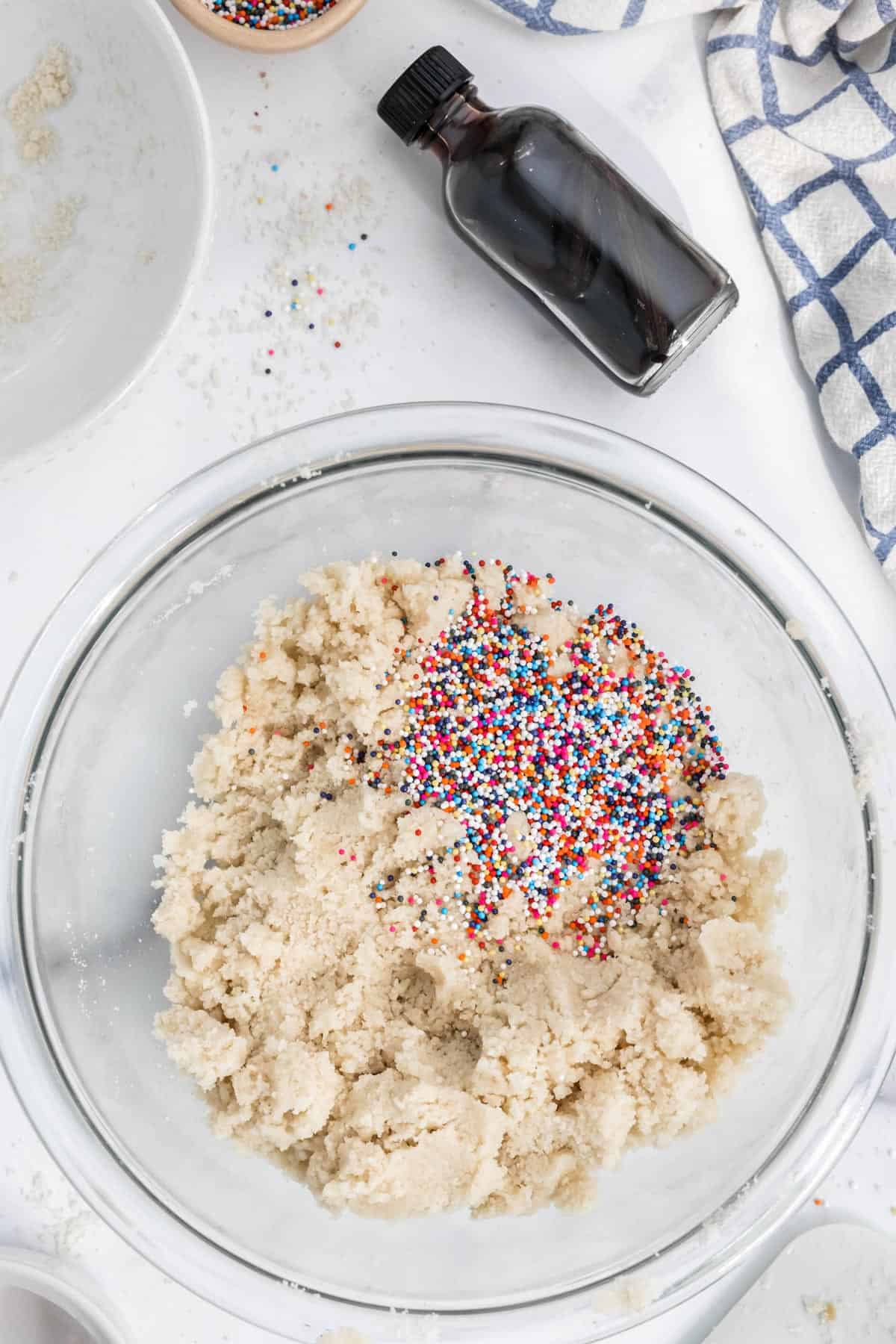 Adding rainbow sprinkles to the batter.