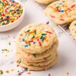 Stack of cookies in front of a cooling rack of more.