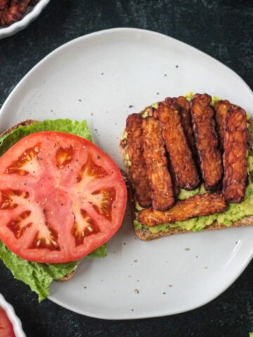 Tempeh bacon on an open face sandwich.