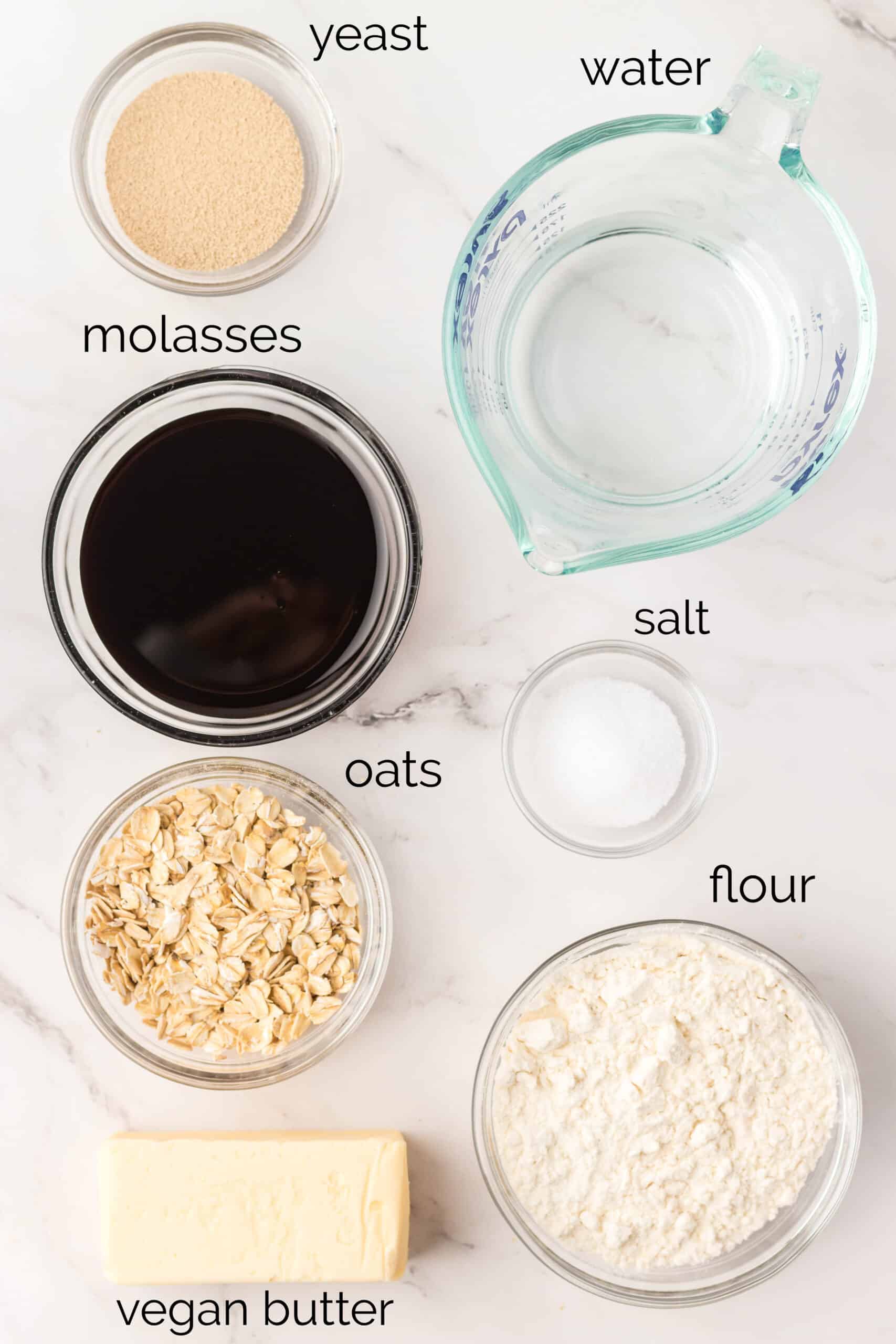 Labeled molasses oatmeal bread recipe ingredients arrayed in individual bowls.