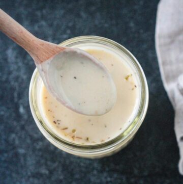 Spoonful of sauce being lifted from a jar.