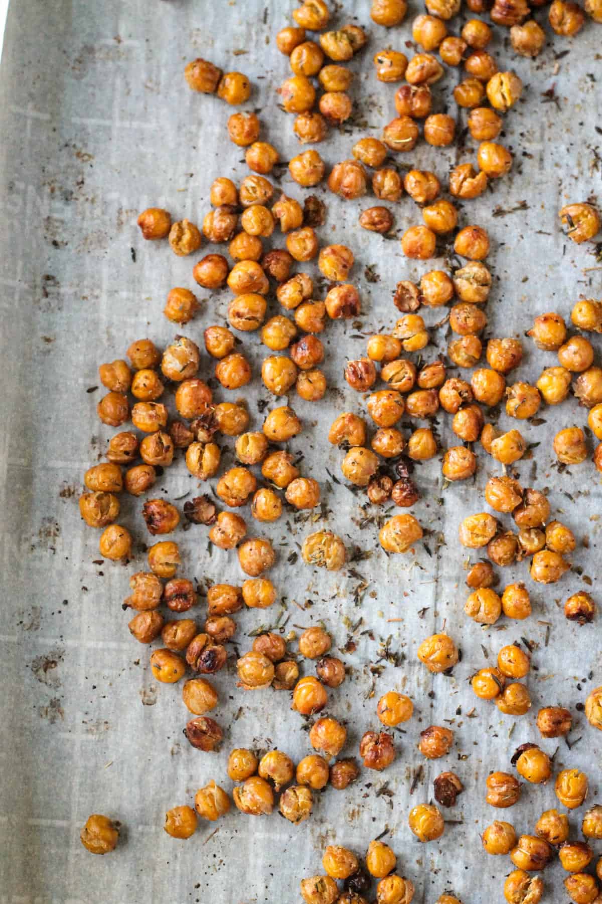 Baked chickpeas on a parchment lined baking sheet.