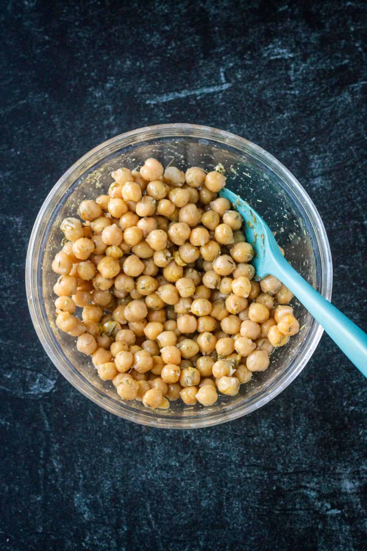 Garbanzo beans with seasonings in a mixing bowl.
