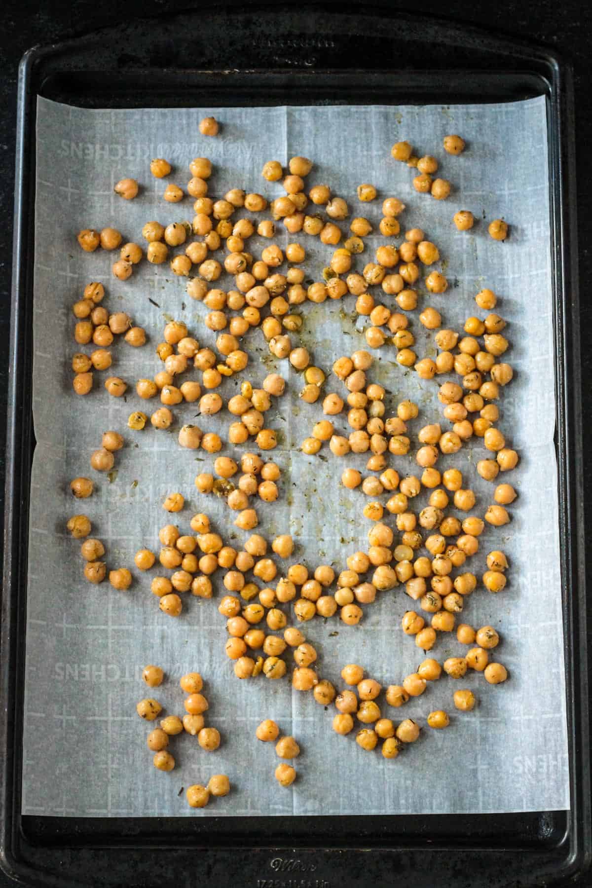 Seasoned chickpeas spread out on a pan.