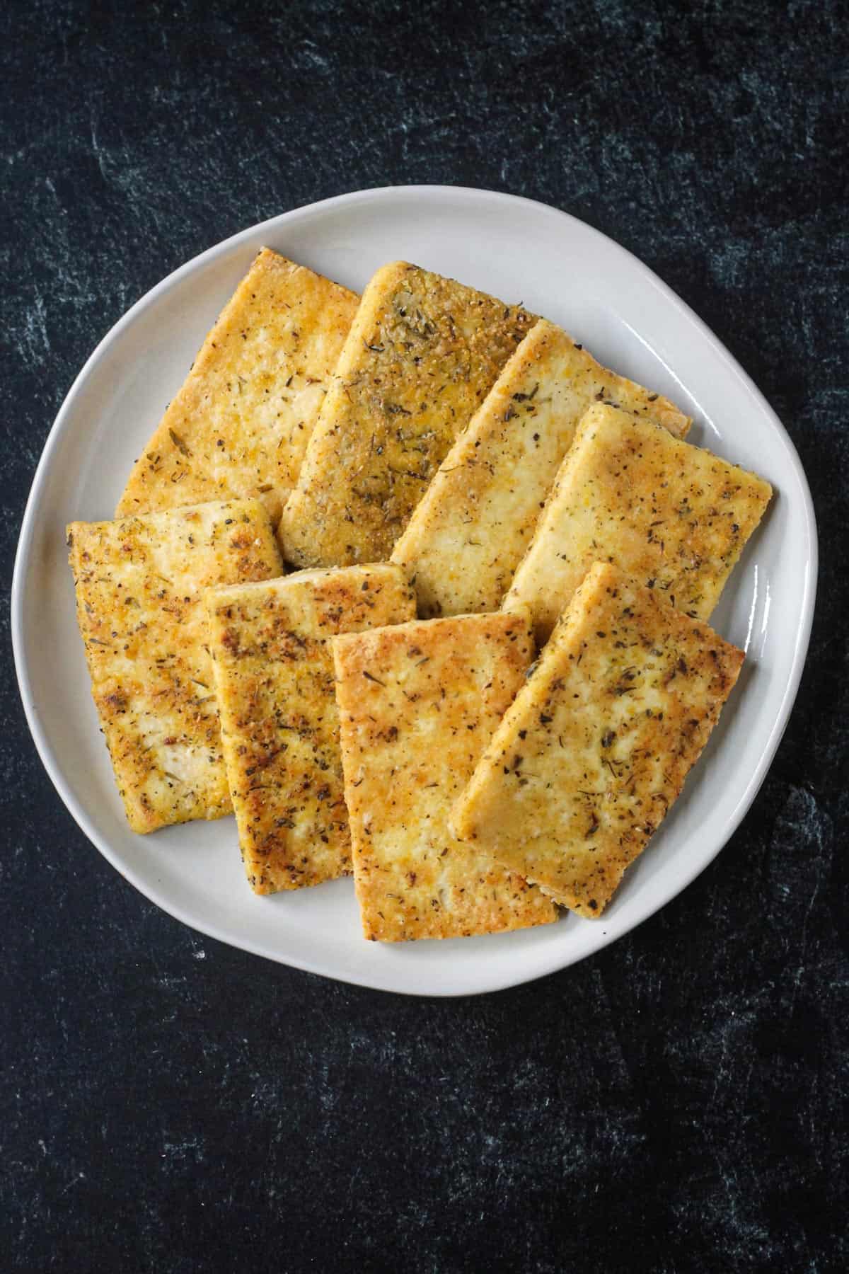 Eight slices of golden pan fried tofu.
