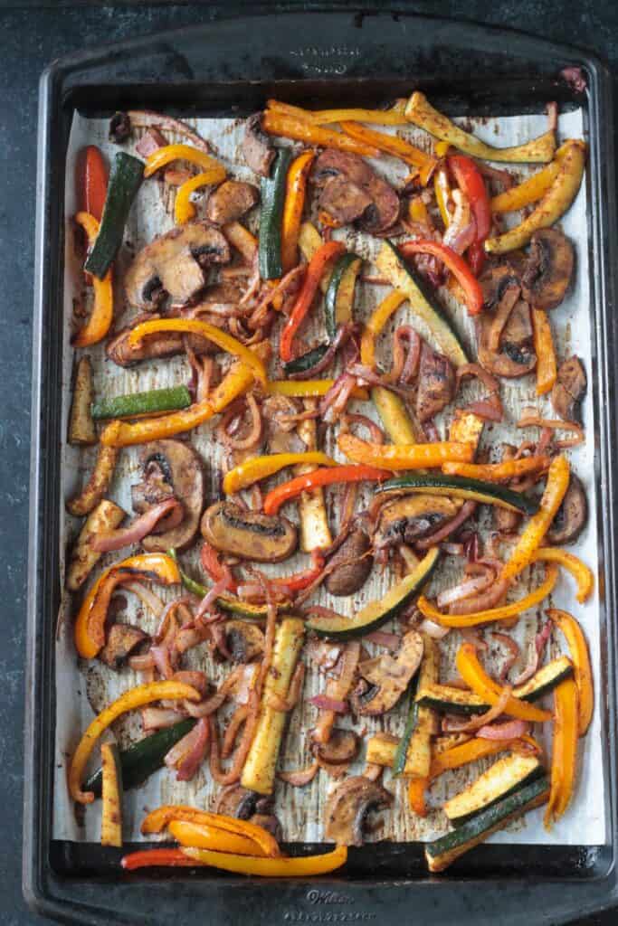 Roasted sliced veggies on a sheet pan.