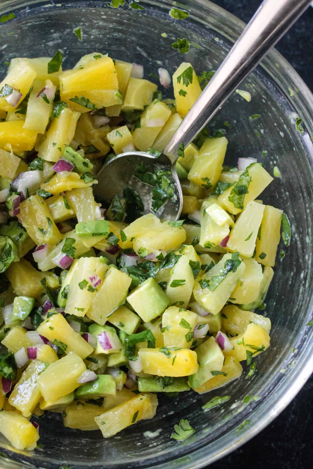 Close up of diced pineapple and avocado in a fruit salsa.