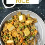Curry fried rice with peas and carrots on a plate with two forks.