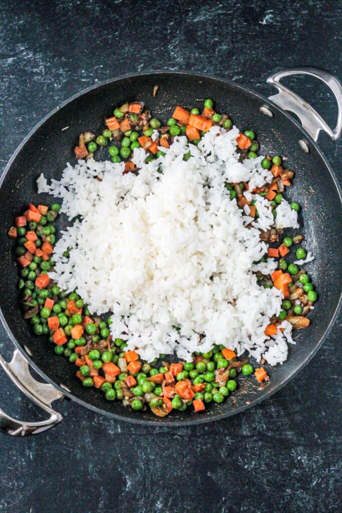 Cooked white rice added to the skillet.