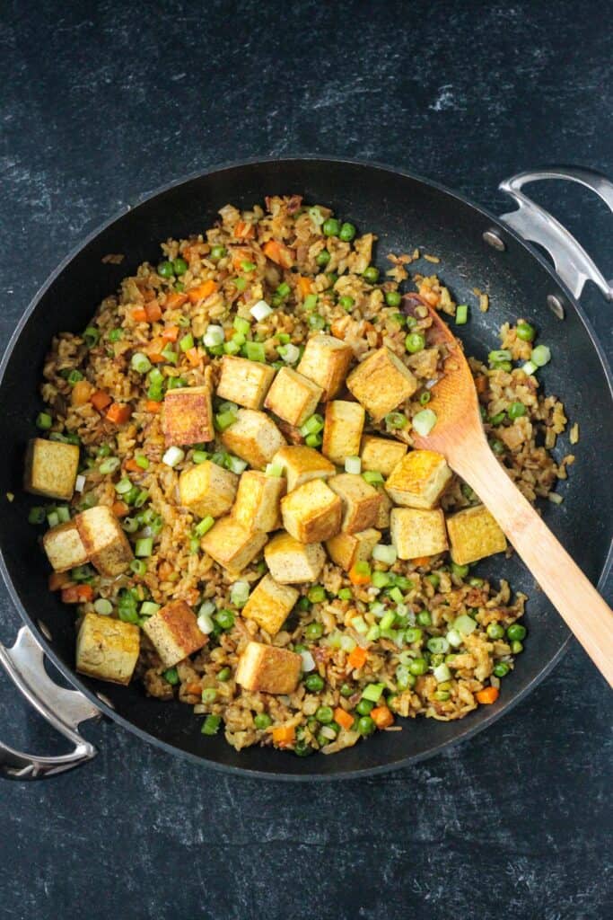 Fried tofu cubes added to the skillet of curry fried rice.