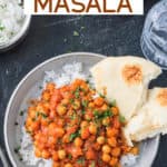 Chickpea tikka masala plated over rice with a side of naan.